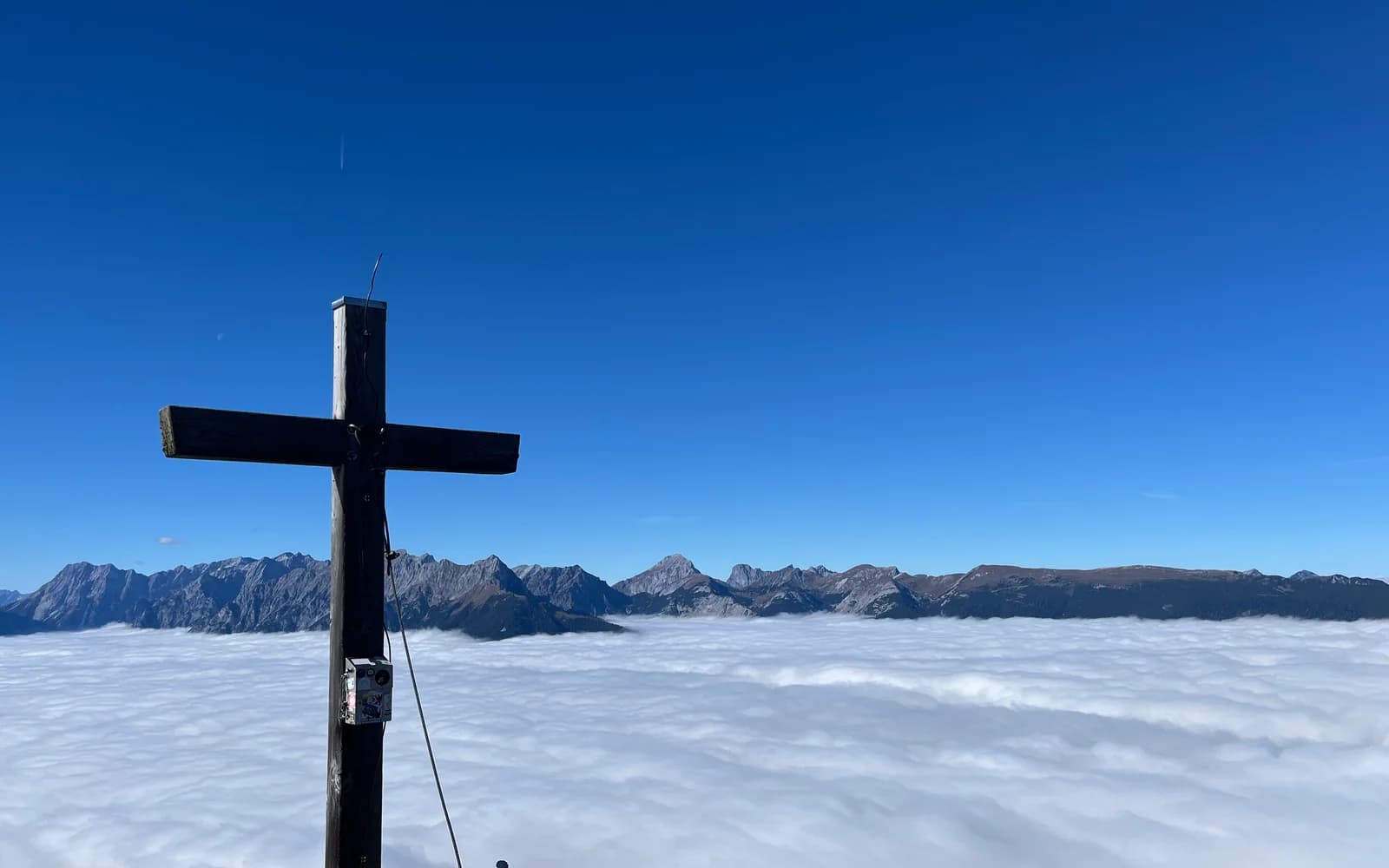 Gipfelkreuz vor dem Himmel als Sinnbild für persönliche Trauerrituale