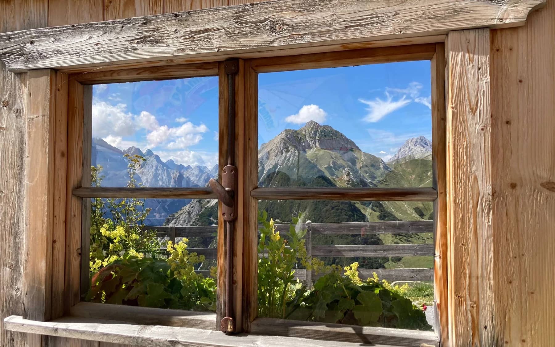 Ruhiger Bergblick durch ein Fenster als Symbol fuer eine Bestattungsvorsorge